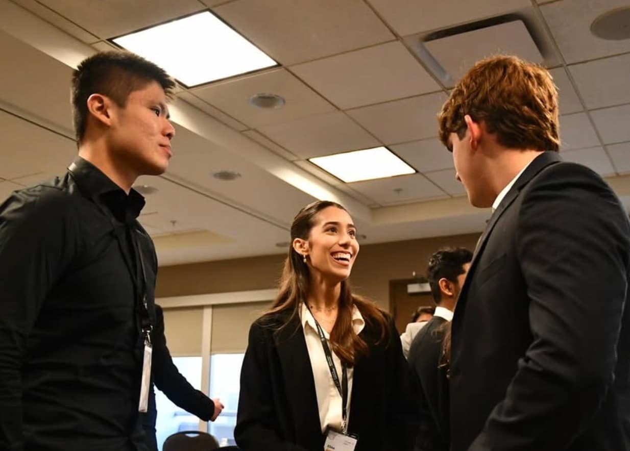Three attendees laughing together between sessions