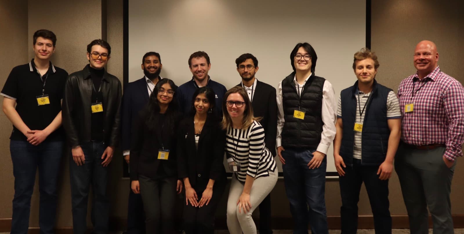 Founders, judges and organizers lined up in front of the stage screen